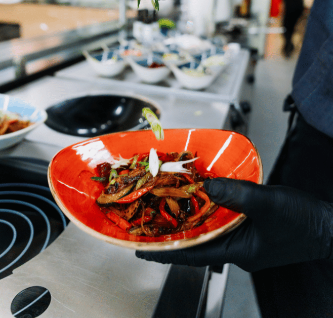 Frisch zubereitetes Wok-Gemüse. Gemüse rieselt in den Teller.